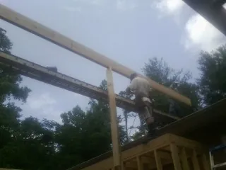 Carpenter setting a ridge beam over a new addition frame — Ice Dam Removal by Roofing Brothers in Oysterville
