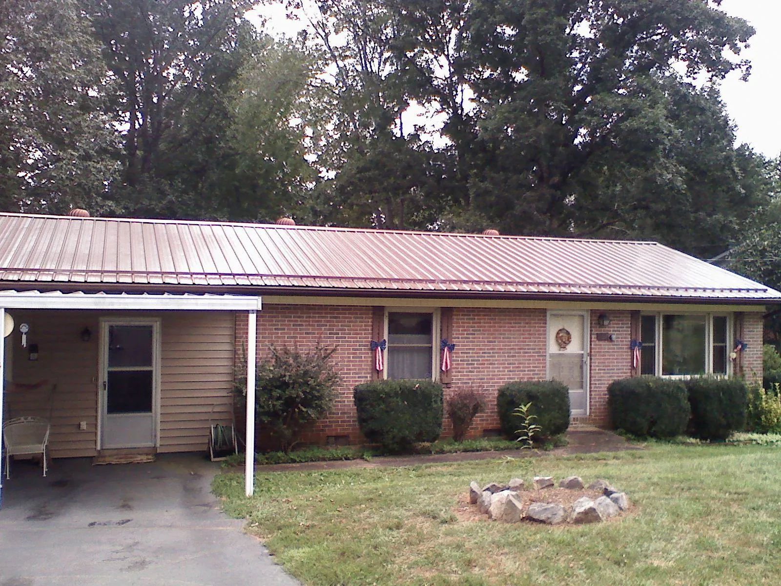 Bronze metal roof and carport on a brick ranch home — Roof Repair work by our crew in Oysterville